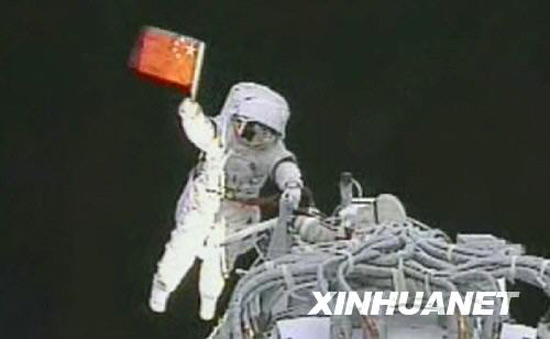 9月27日,執(zhí)行神舟七號載人航天飛行出艙活動任務(wù)的航天員翟志剛在艙外揮動中國國旗。 新華社發(fā)(電視截圖)